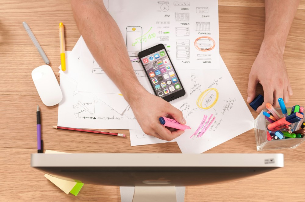 Man highlighting creative work at desk