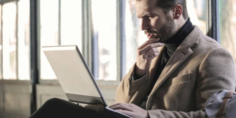 Man Considering Options on Laptop