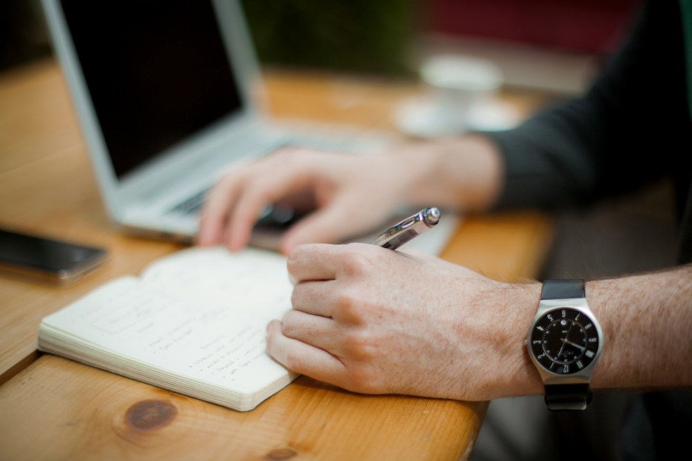 Man writing a list in his notebook