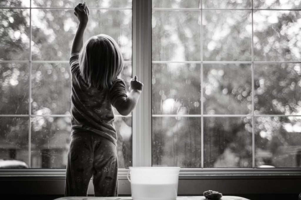 Child cleaning the glass at home